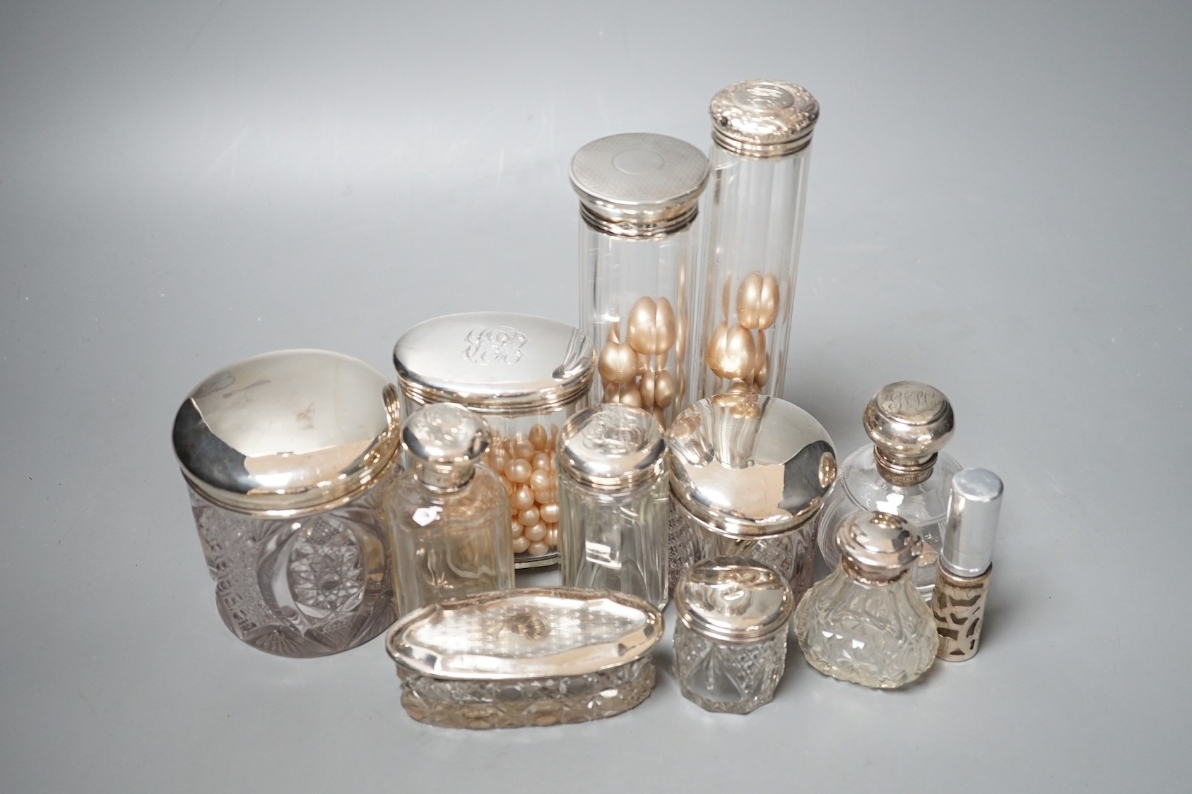 A group of assorted silver topped glass toilet bottles and a scent bottle.